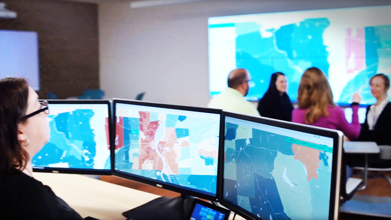 People engaged in conversation while viewing a presentation in the Visualization Studio