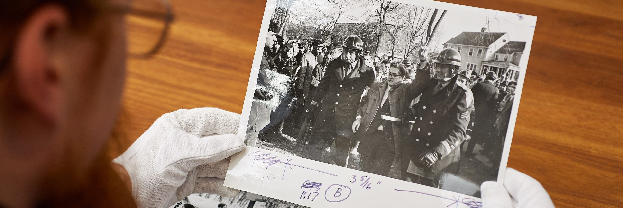 Archivist holding historic photograph of UConn student protest